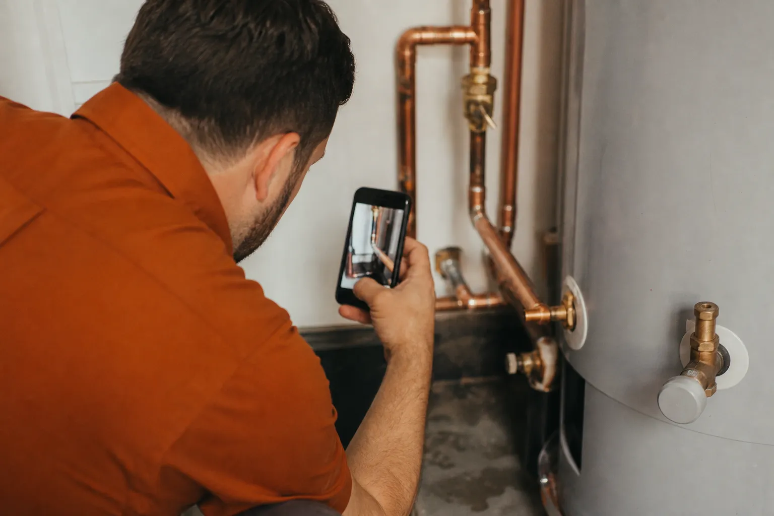 A home service technician photographing a completed repair with a smartphone