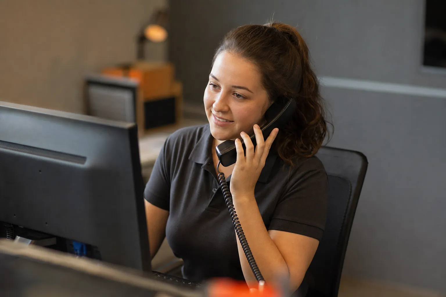 A home service office dispatcher answering a phone call at a desk