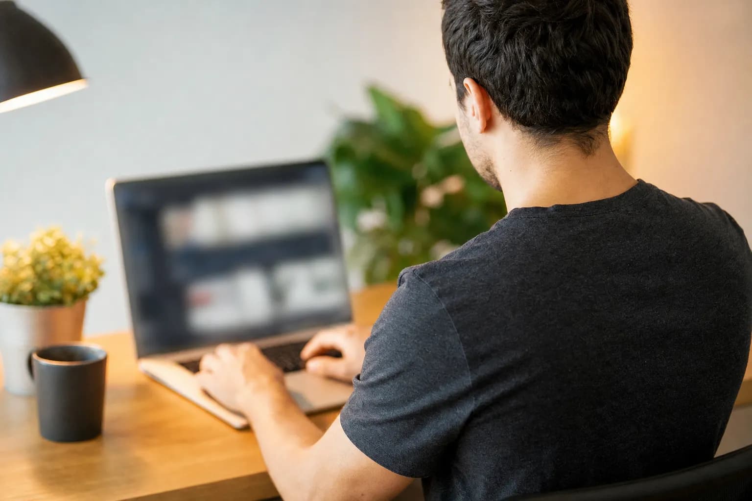 A web designer working on a laptop at a desk, building and optimizing web pages